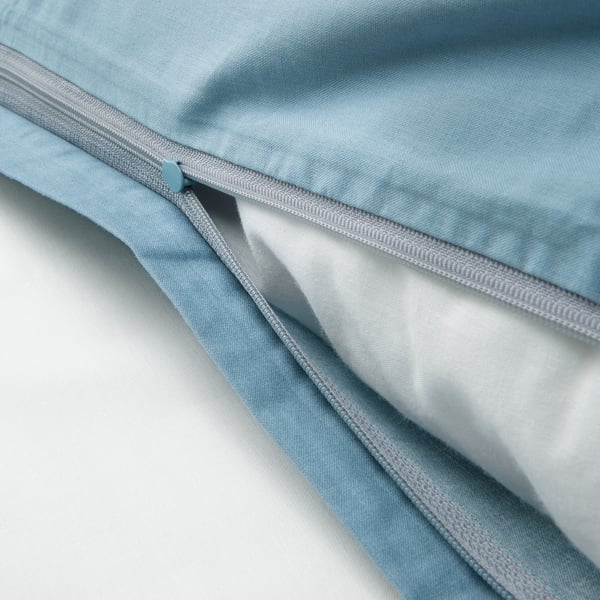 Close-up of a blue VÄNKRETS duvet cover with zip partially opened, showing inner fabric.