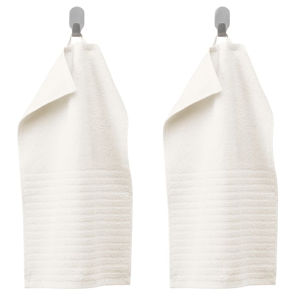 Two white VÅGSJÖN towels hang on silver hooks, texture visible.