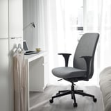 Minimalist grey VALLFJÄLLET office chair by small desk with laptop and coffee.