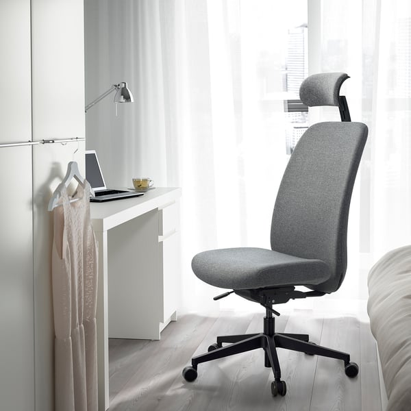 Modern ergonomic VALLFJÄLLET office chair near desk with laptop and cup.