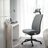 Modern ergonomic VALLFJÄLLET office chair near desk with laptop and cup.
