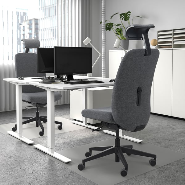 Minimalist office with VALLFJÄLLET chairs, dual monitors, large windows.