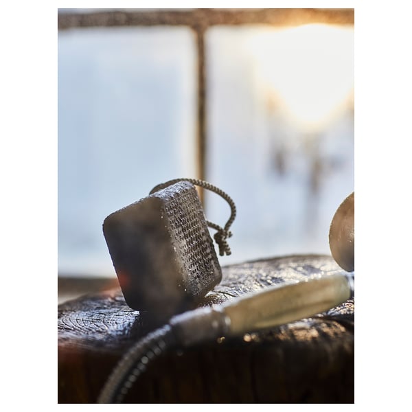 Black VAPPEBY portable speaker, small and sleek, sits on a textured surface, waterproof and ready for travel.