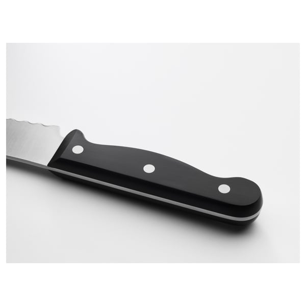 Close-up of a serrated knife with a black handle and silver blade, showcasing its sharp edge and sturdy design.
