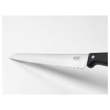 Serrated kitchen knife with black handle; stainless steel blade; designed for cutting bread and soft vegetables.