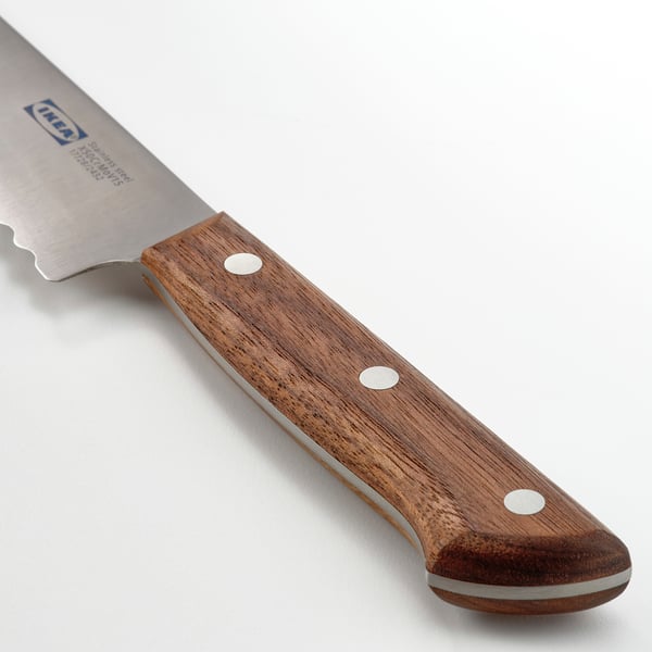 Knife with serrated blade and dark walnut handle, showcasing sharp and balance quality.