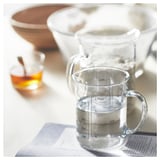 Clear glass measuring jug with handle and volume markings. Kitchen tool for liquids.