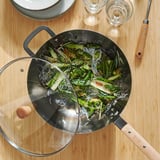 Stir-fried vegetables and noodles in wok on table.