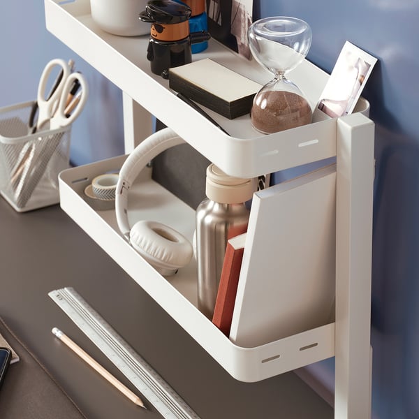 Desk organizer with headphones, water bottle, books, sand timer, scissors, utensils.