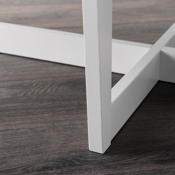 White metal magazine rack with dark wooden floor, neat and stable design.