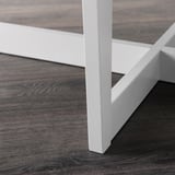 White metal magazine rack with dark wooden floor, neat and stable design.