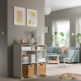 Modern living room with gray storage unit, wicker baskets, blue sofa, and artwork.