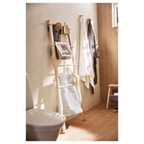 Bathroom with white VILTO birch towel stand, striped bag, hanging towels, sink, and stool.