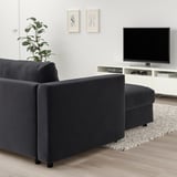 Modern living room: dark gray VIMLE sectional sofa, sleek tv stand, plant, abstract art.