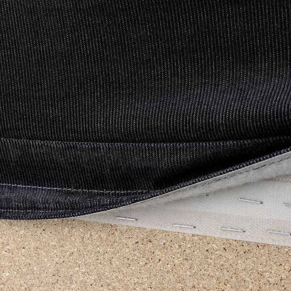 Black sofa fabric with visible stitching and zipper, showcasing removable cover for easy cleaning.