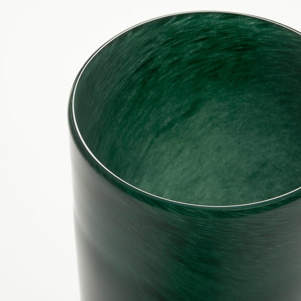 Dark green, handcrafted glass candle holder with wavy, reflective finish.