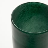Dark green, handcrafted glass candle holder with wavy, reflective finish.