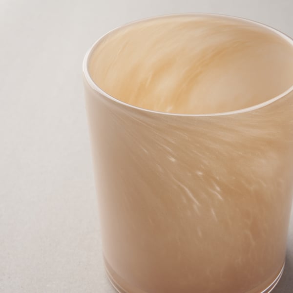 Clear, handcrafted glass candle holder with a subtle, textured pattern, reflecting soft light.