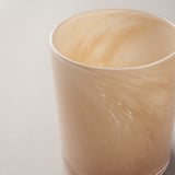 Clear, handcrafted glass candle holder with a subtle, textured pattern, reflecting soft light.