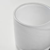 Close-up of a handcrafted glass candle holder. Smooth, frosted surface reflects light subtly.