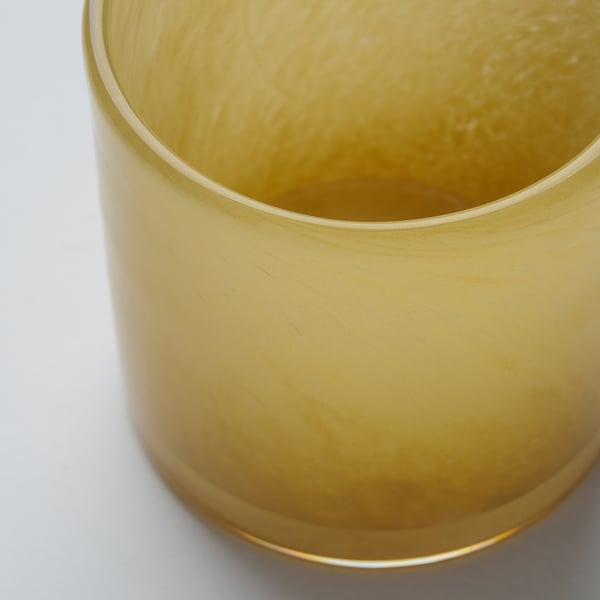 Golden, handcrafted glass candle holder, close-up view, showcasing intricate, reflective pattern.