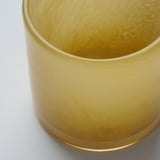 Golden, handcrafted glass candle holder, close-up view, showcasing intricate, reflective pattern.