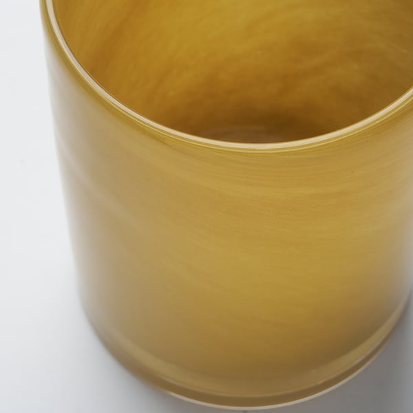 Gold-colored, polished glass candle holder with smooth surface, viewed from above.