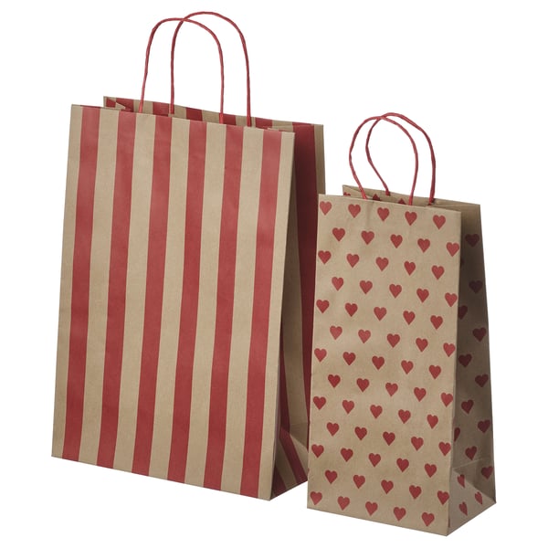 Two brown paper bags, one striped red, one with red hearts, both with red handles.