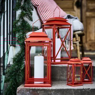 Three VINTERFINT red lanterns, varying sizes, two with candles, outdoors on steps with evergreens and tent.