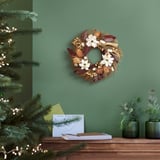 VINTERFINT wreath on green wall between tree and table