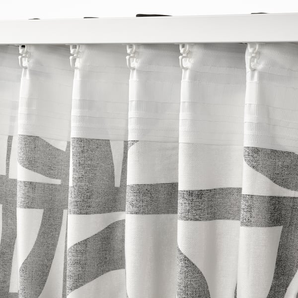 Black and white patterned curtains hang with hooks, providing privacy and style.
