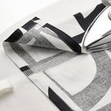 Black and white patterned curtains folded, iron on top. Curtains from VINTEROXBÄR collection.