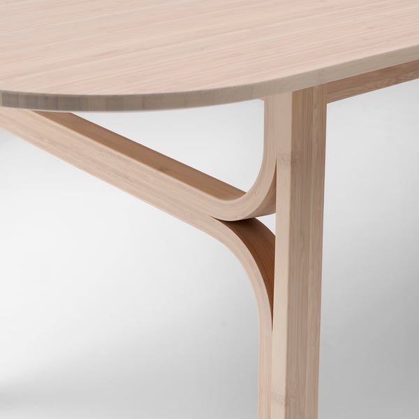 Close-up of modern, light-colored wooden table corner, smooth finish.