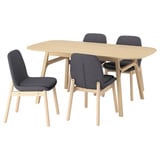 A VOXLÖV dining set with a light brown table and four dark grey chairs.