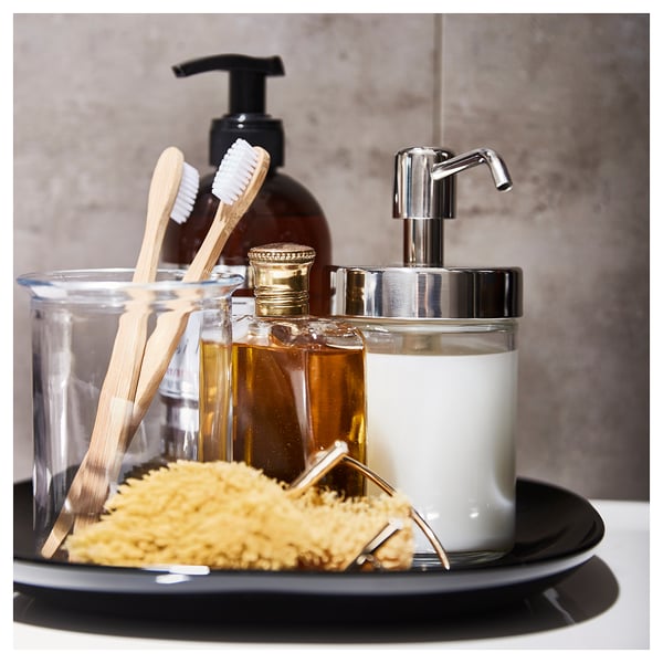 A VOXNAN bathroom set with glass soap dispenser, toothbrush holder, and amber bottle, all with chrome accents, on a black tray.