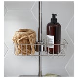 Metal bathroom shelf, holding a woven basket and soap bottle, attached to a shower rail.