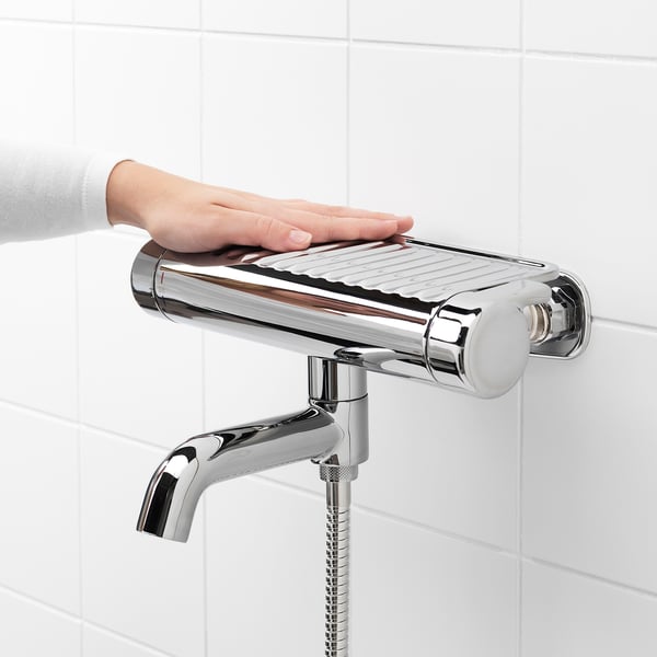 Chrome shower mixer on wall with shelf, temperature control up to 38°c.