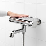 Chrome shower mixer on wall with shelf, temperature control up to 38°c.