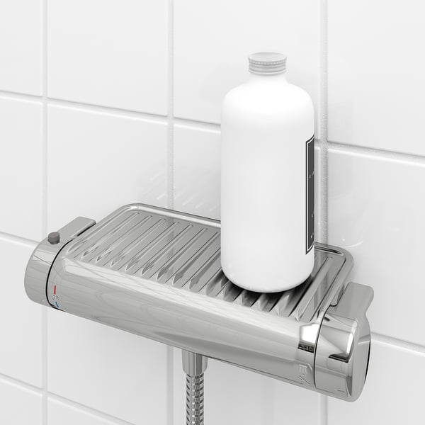 Shower mixer with built-in shelf holding bottle, safety stop button, and anti-scald technology.