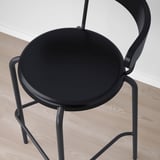 Modern black bar stool with sleek, curved design. A round seat and compact frame, ideal for small spaces.