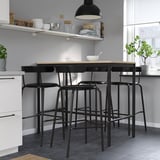 Modern kitchen with black YNGVAR stools. Rounded, beech veneer, durable, complements decor, hangs for easy cleaning.