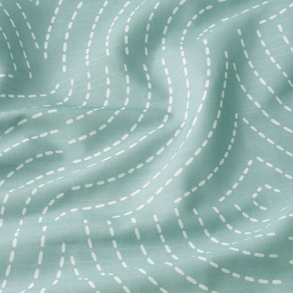 Mjuka, strukturerade havsgröna gardiner med vita mönster, troligen återvunnen polyester, snyggt draperade.