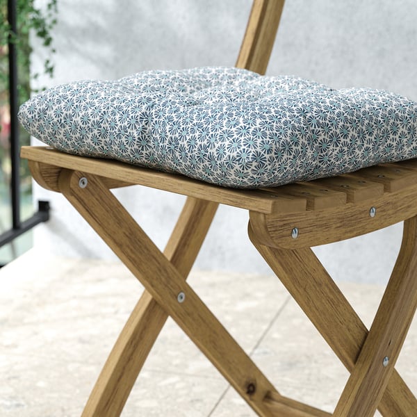 Utomhusstol i trä med mönstrad dyna; robust, hopfällbar design, akaciaträ; Vändbar dyna, 100% återvunnen polyester.