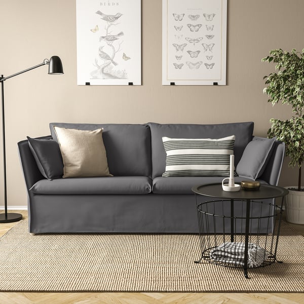 Modern grå BACKSÄLEN soffa med avtagbar klädsel i mysigt vardagsrum. Accentuerad med kuddar, sidobord, konst, lampa och växt.