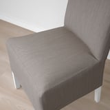 Närbild av en modern, stoppad stol i grått tyg på ett trägolv som visar upp sin eleganta design och bekväma, stödjande ryggstöd.