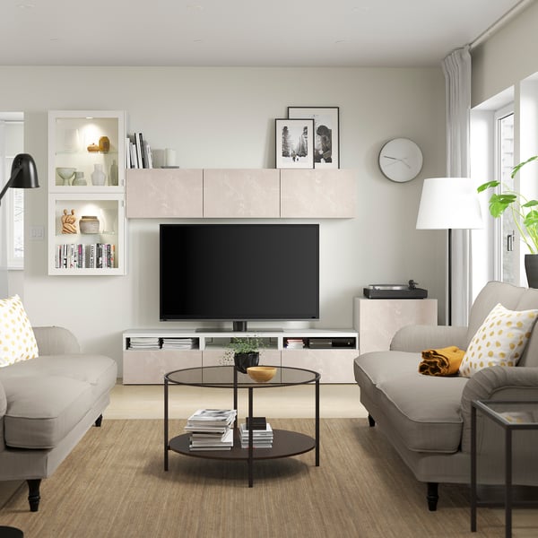 Vardagsrum: BERGSVIKEN tv-bänk, grå soffor, soffbord i glas, golvlampa, väggklocka.