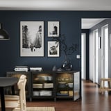 Modern matsal med grå väggar, BESTÅ-enhet, foton, vas, jordnära inredning, trägolv, minimalistiska möbler.