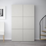 Den vita garderoben BESTÅ är hög, dubbelt så hög som den närliggande stolen, med sex fyrkantiga fack, modern minimalistisk design.