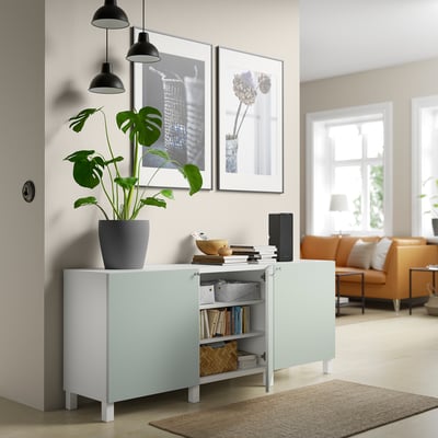 Sideboard BESTÅ i vit med tre ljusgröna skåpdörrar. Den har en modern design med fyrkantiga ben och justerbara gångjärn.