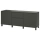 Sideboard, en svart ikea BESTÅ. Den har lådor och skåp med en elegant, modern design. Förvaringen är rektangulär och står på fyra ben.